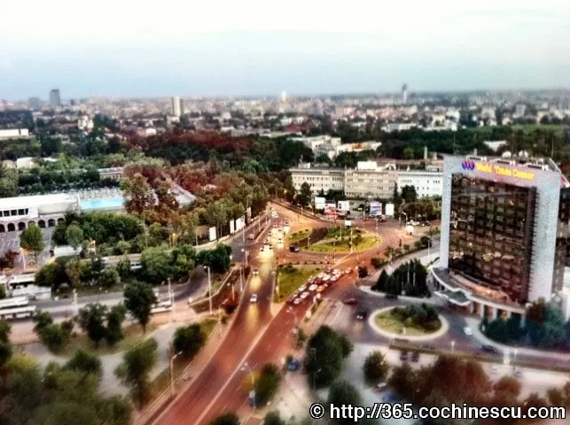 A busy intersection and the buildings of Bucharest are seen from high above.